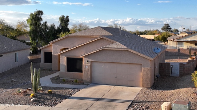 ranch-style home with concrete driveway, stucco siding, fence, and a garage