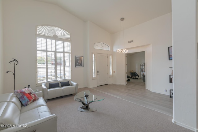 carpeted living room with high vaulted ceiling