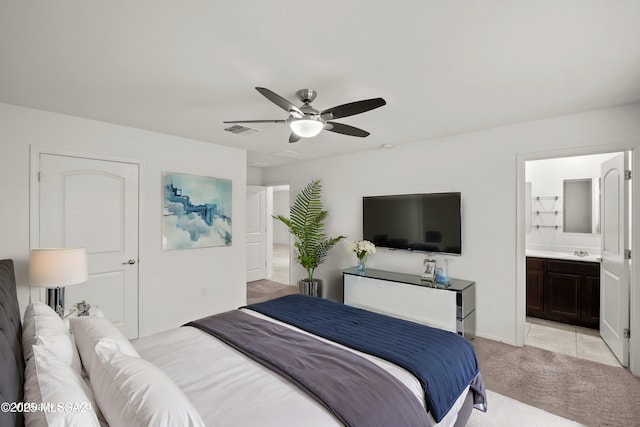 carpeted bedroom featuring ceiling fan, ensuite bathroom, and sink