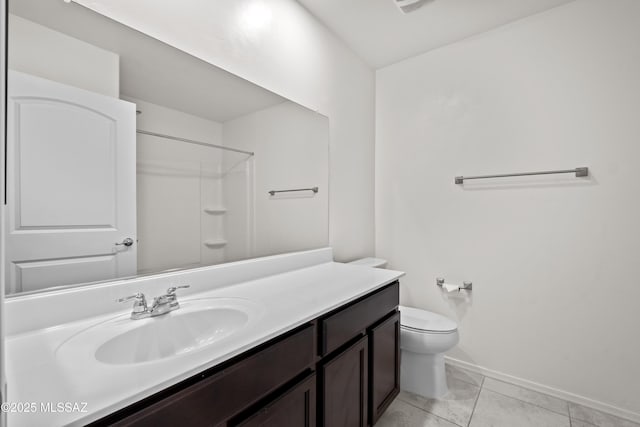 bathroom with a shower, vanity, tile patterned floors, and toilet