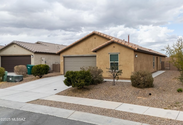 view of front facade with an attached garage, stucco siding, fence, and concrete driveway