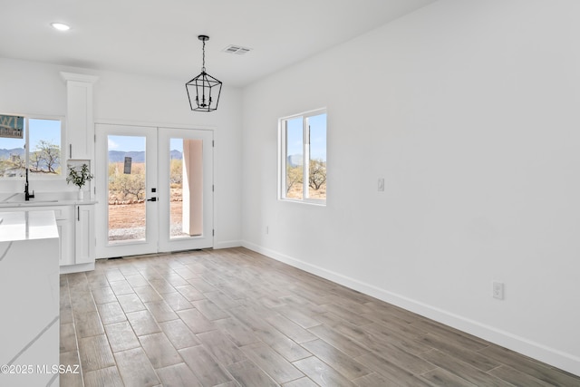 interior space featuring french doors, sink, a chandelier, and light hardwood / wood-style flooring