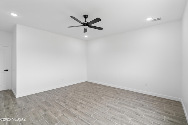 empty room with ceiling fan and light hardwood / wood-style flooring