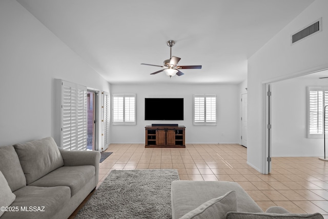 tiled living room featuring vaulted ceiling, plenty of natural light, and ceiling fan