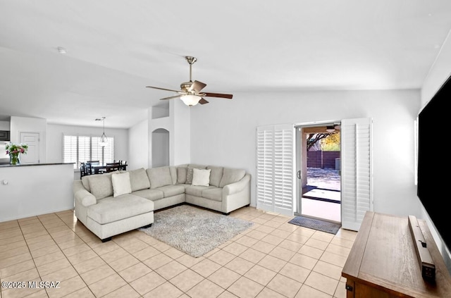 living room with ceiling fan, lofted ceiling, and light tile patterned floors