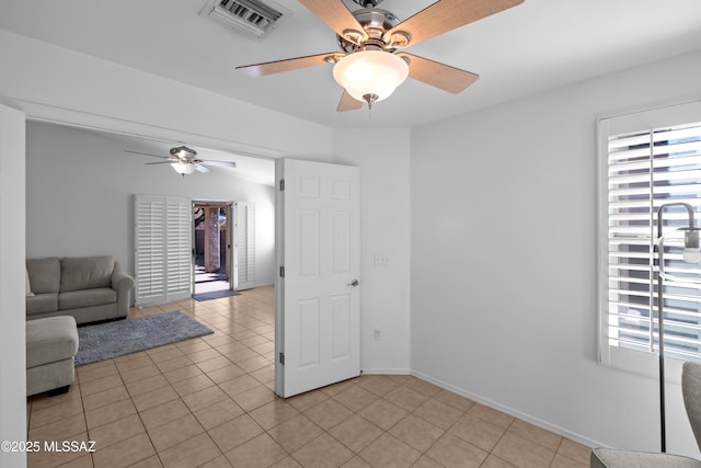 unfurnished living room with light tile patterned floors and ceiling fan