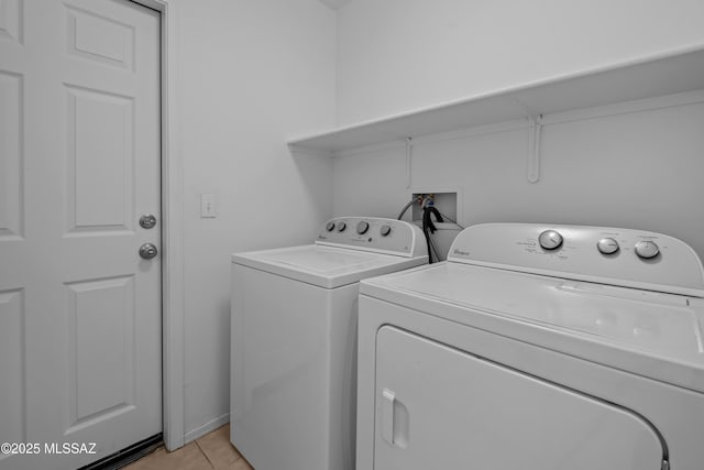 laundry area with light tile patterned flooring and washer and clothes dryer