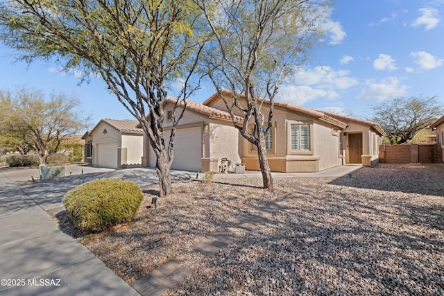 7715 E Fair Meadows Loop, Tucson, AZ 85756 - mediterranean / spanish-style home featuring a garage, concrete driveway, stucco siding, and a tile roof