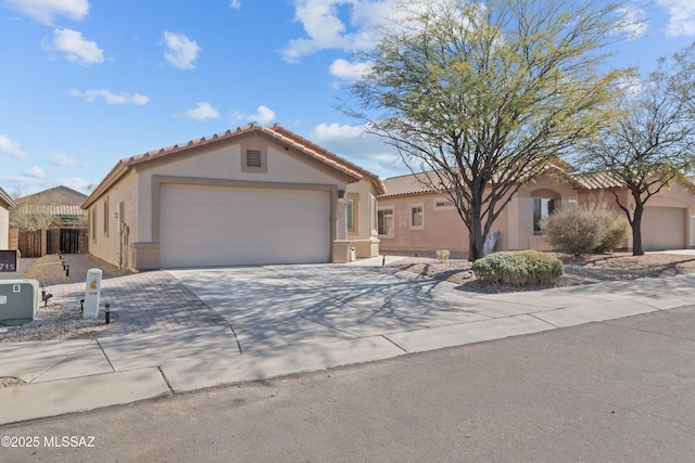 7715 E Fair Meadows Loop, Tucson, AZ 85756 - mediterranean / spanish house with stucco siding, driveway, a tile roof, and an attached garage