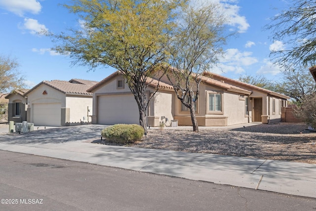 7715 E Fair Meadows Loop, Tucson, AZ 85756 - mediterranean / spanish-style home with an attached garage, stucco siding, concrete driveway, and a tile roof