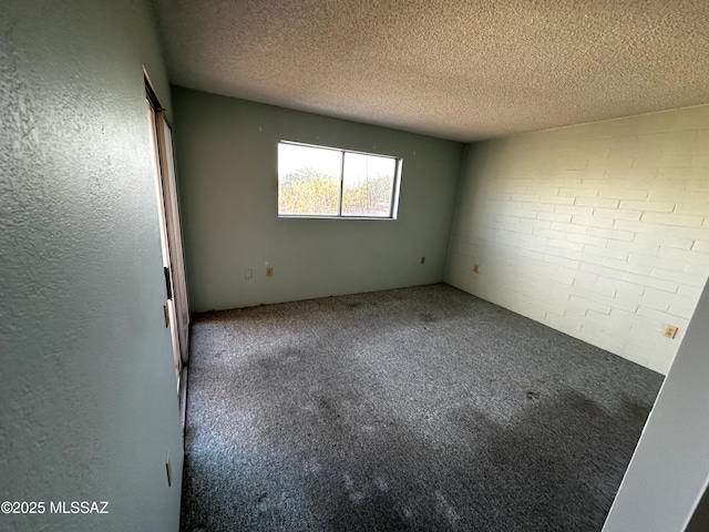 unfurnished room featuring carpet floors and a textured ceiling