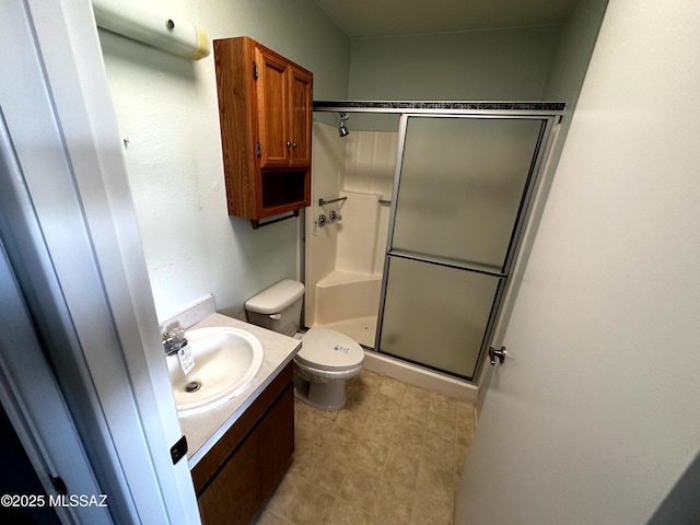 bathroom featuring an enclosed shower, vanity, and toilet