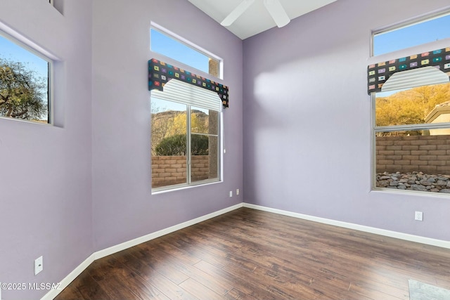 empty room with ceiling fan and dark hardwood / wood-style floors