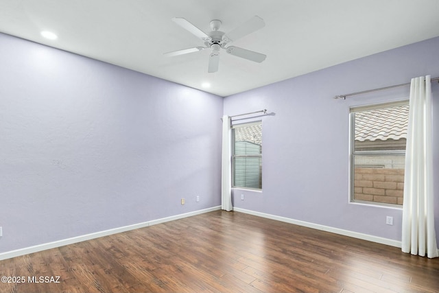 spare room with dark hardwood / wood-style floors and ceiling fan