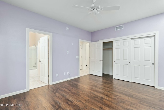 unfurnished bedroom featuring dark hardwood / wood-style floors, connected bathroom, ceiling fan, and a closet