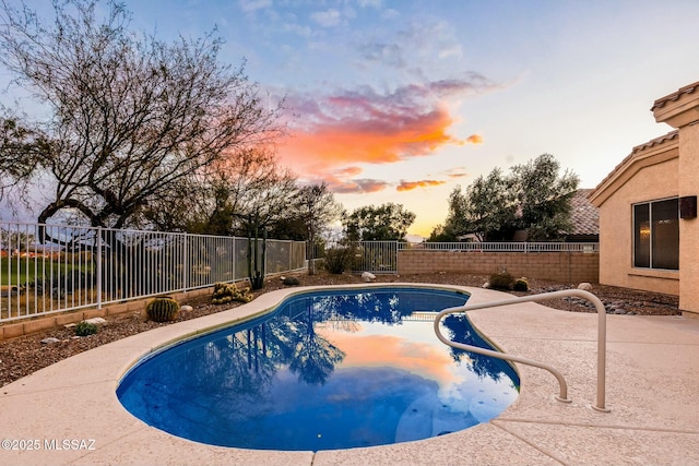 pool at dusk featuring a patio