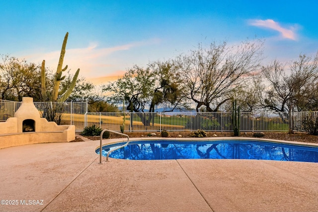 pool at dusk with a patio