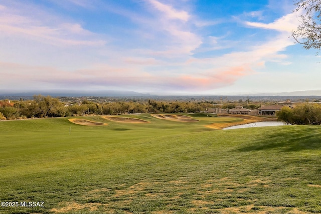 surrounding community with a water view and a lawn