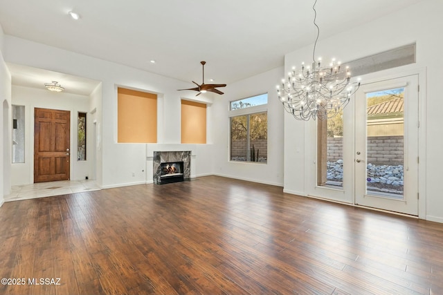 unfurnished living room featuring ceiling fan, a high end fireplace, and dark hardwood / wood-style flooring