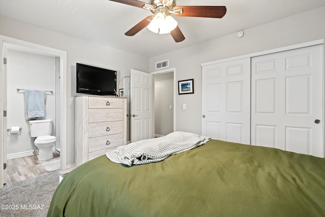 bedroom featuring light carpet, connected bathroom, a closet, and ceiling fan