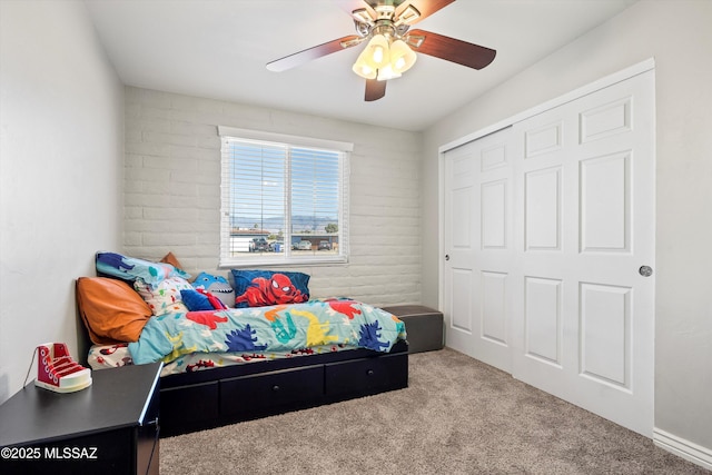 carpeted bedroom featuring ceiling fan and a closet