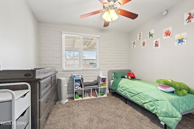 carpeted bedroom featuring brick wall and ceiling fan