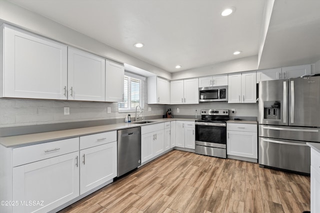 kitchen with sink, white cabinets, and appliances with stainless steel finishes