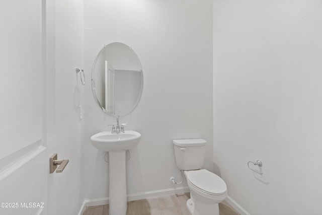 bathroom with sink, hardwood / wood-style flooring, and toilet