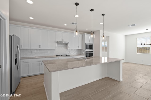 kitchen with sink, white cabinetry, a kitchen island with sink, stainless steel appliances, and decorative light fixtures