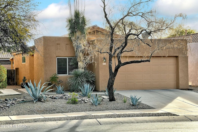 pueblo-style house featuring a garage