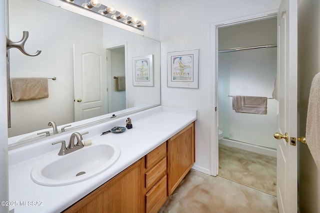 bathroom with a shower with door, vanity, tile patterned floors, and toilet