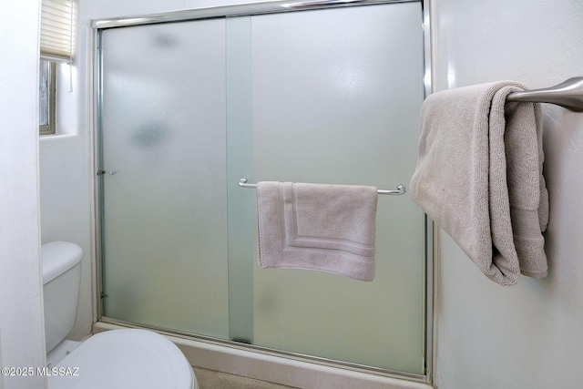 bathroom with an enclosed shower and toilet