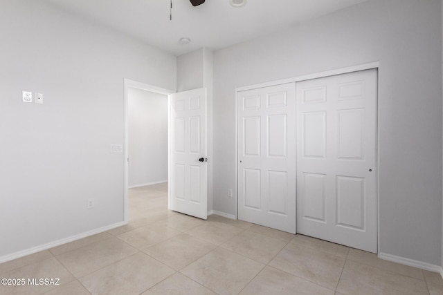 unfurnished bedroom with light tile patterned floors, a closet, and ceiling fan