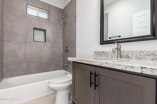 full bathroom featuring vanity, tile patterned flooring, tiled shower / bath combo, and toilet