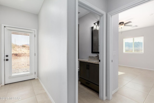 hallway with sink and light tile patterned floors