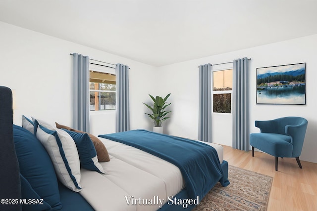 bedroom featuring multiple windows and light hardwood / wood-style floors