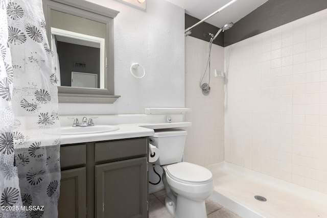 bathroom with vanity, tile patterned flooring, toilet, and walk in shower