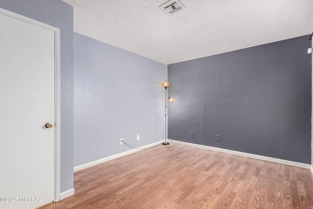 spare room with hardwood / wood-style floors and a textured ceiling