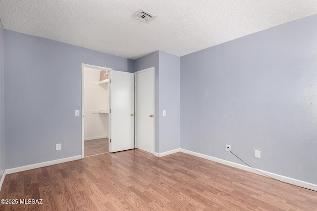 unfurnished bedroom featuring light hardwood / wood-style floors and a textured ceiling