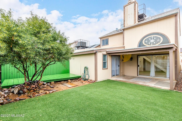 rear view of property with a yard and a patio area