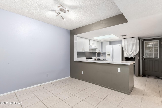 kitchen with white cabinetry, sink, white fridge with ice dispenser, kitchen peninsula, and a textured ceiling