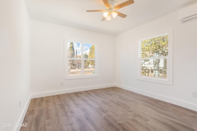 empty room featuring ceiling fan, a wall mounted air conditioner, and light hardwood / wood-style floors