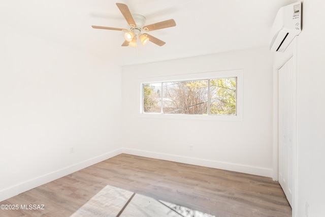 unfurnished room with an AC wall unit, ceiling fan, and light hardwood / wood-style flooring