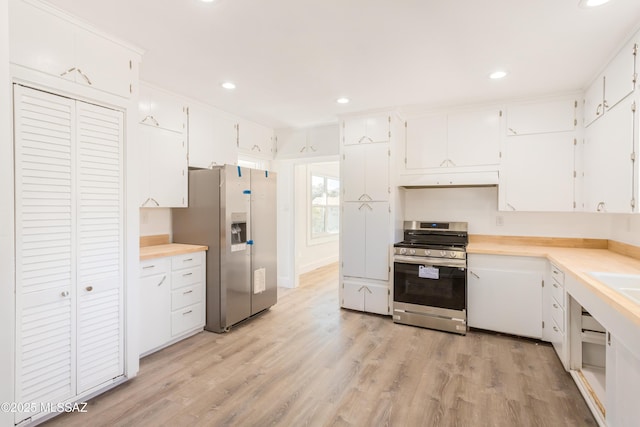 kitchen with white cabinetry, appliances with stainless steel finishes, crown molding, and light wood-type flooring
