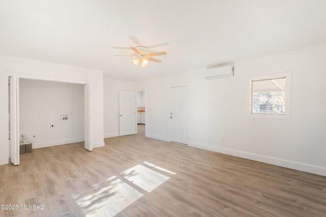 unfurnished room featuring ceiling fan, a wall mounted air conditioner, and light hardwood / wood-style floors