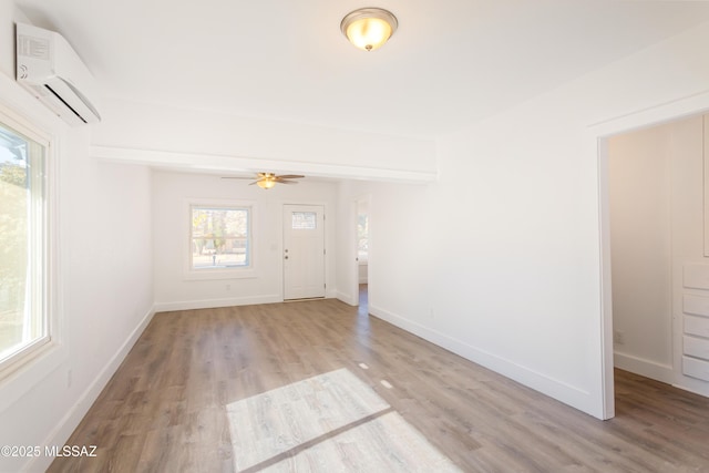 interior space with a wall unit AC and light wood-type flooring