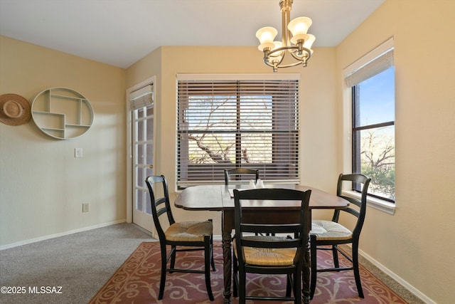 carpeted dining room featuring a notable chandelier