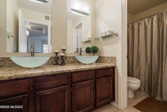 bathroom with tile patterned flooring, vanity, and toilet