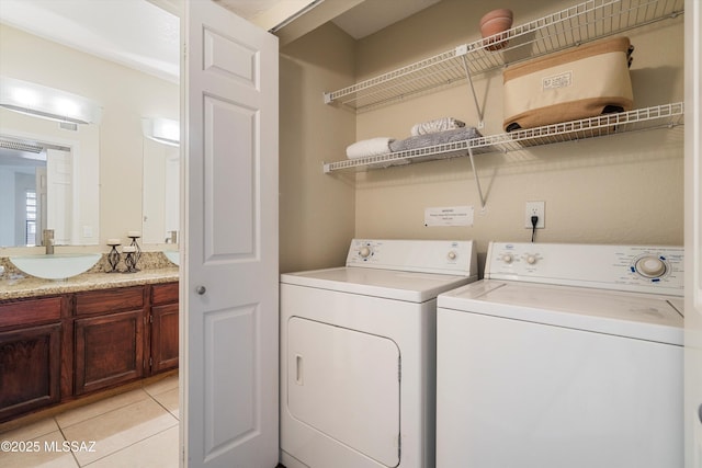 laundry area featuring sink, light tile patterned floors, and washer and clothes dryer