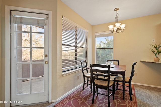 carpeted dining space with a chandelier